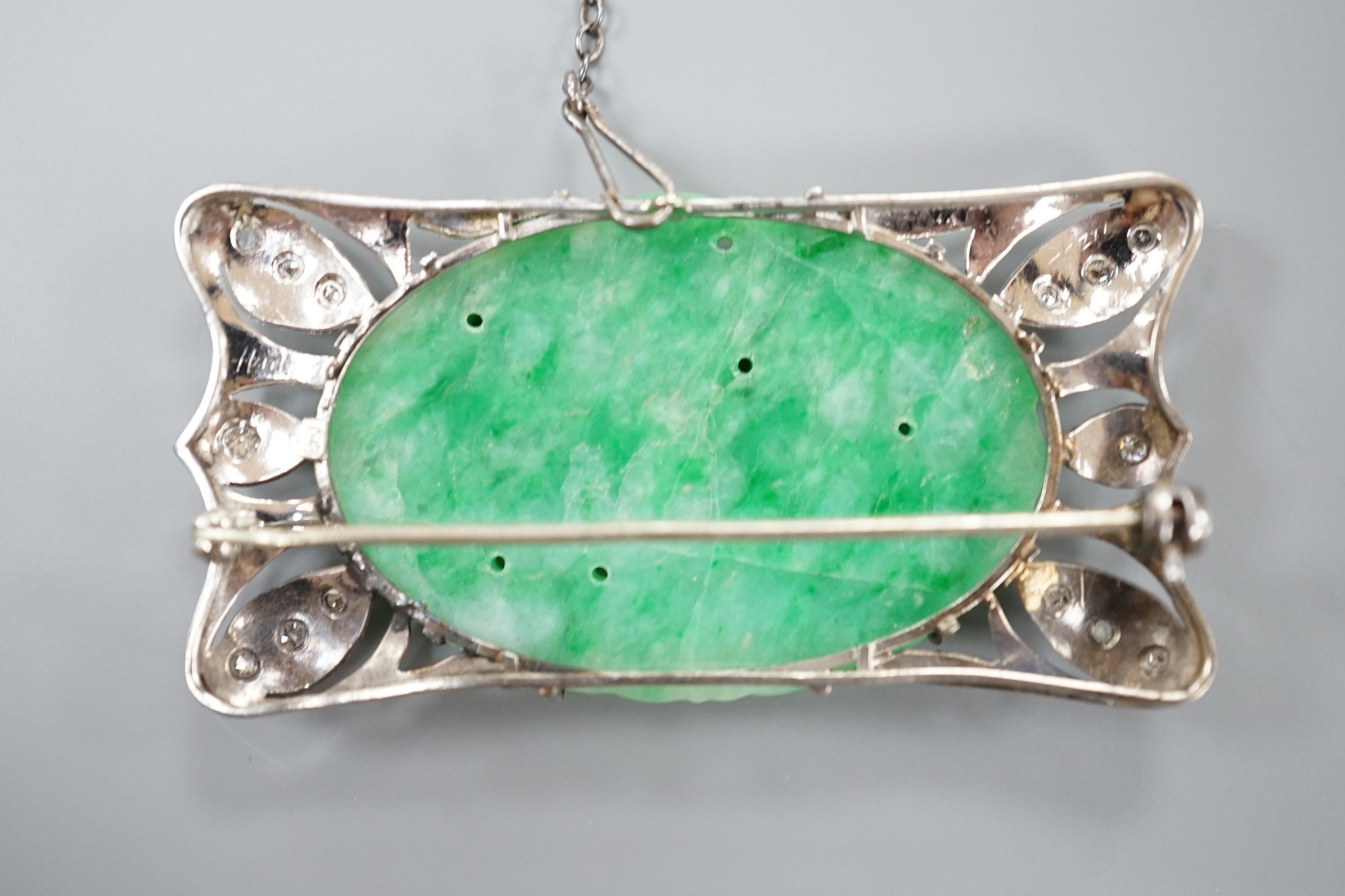 A white metal (stamped 9C?), diamond chips and oval carved jade set shaped rectangular brooch, 52mm, gross weight 13.1 grams.